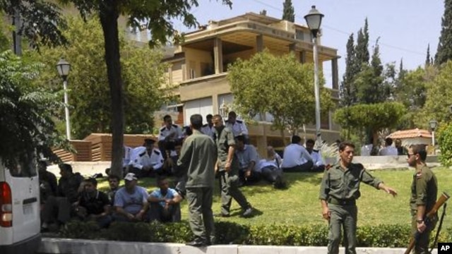 Syrian soldiers and police members secure the area near the U.S. Embassy in Damascus, July 12, 2011.