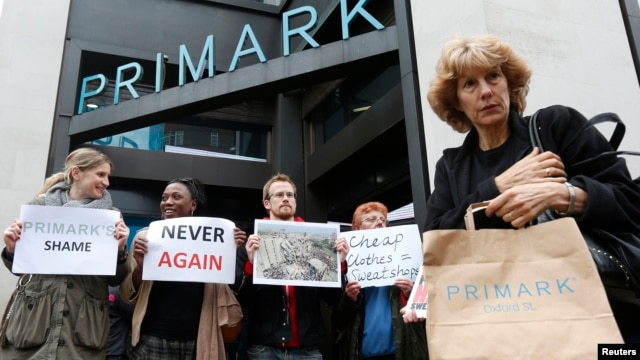 A shopper passes demonstrators outside clothing retailer Primark in central London, April 27, 2013. 