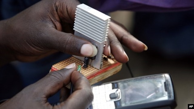 Jeremiah Murimi, a Kenyan electrical engineering student demonstrates how a 'smart charger' connected to a bicycle powers a mobile phone at the University of Nairobi. (File Photo)