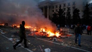 Um manifestante passa por um acampamento pró-russa em chamas perto do prédio do sindicato em Odessa, Ucrânia, 2 de maio de 2014. 
