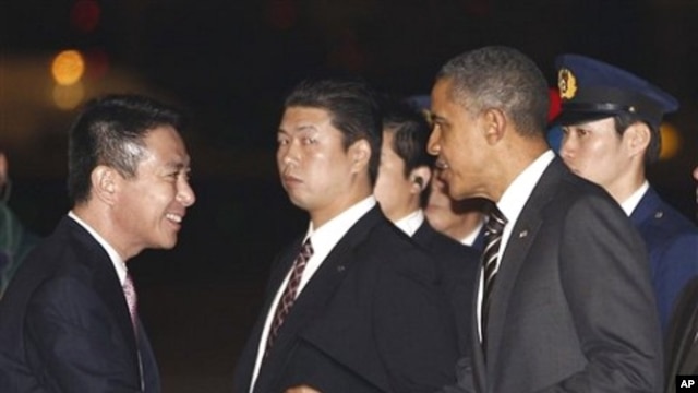 U.S. President Barack Obama is greeted by Japanese Foreign Minister Seiji Maehara as he arrives at Haneda Airport in Tokyo, 12 Nov 2010