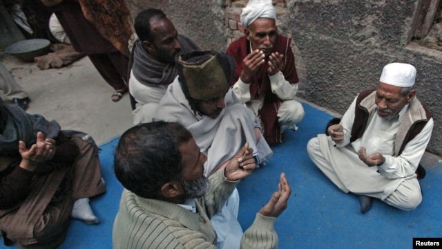 Neighbors pray outside the residence of 62-year-old heart patient Chaudhry Mohammad Gulab after he was buried in Lahore on January 27, 2012. Gulab's health started to deteriorate after he was prescribed a new medication, his younger brother said. 