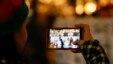 A woman uses a mobile device to take a photograph Dec. 17, 2015, in Glendale, California. (AP Photo)