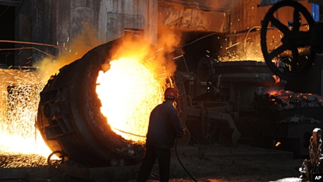 A worker stokes a giant burning cauldron at a steel mill in Hefei, in eastern China's Anhui province, June 25, 2011 (file photo)