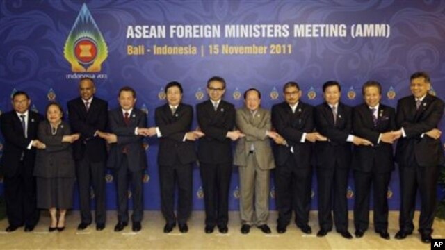 ASEAN foreign ministers and their representatives hold hands during a group photo session of the ASEAN Foreign Ministers Meeting at Bali, Indonesia, November 15, 2011.