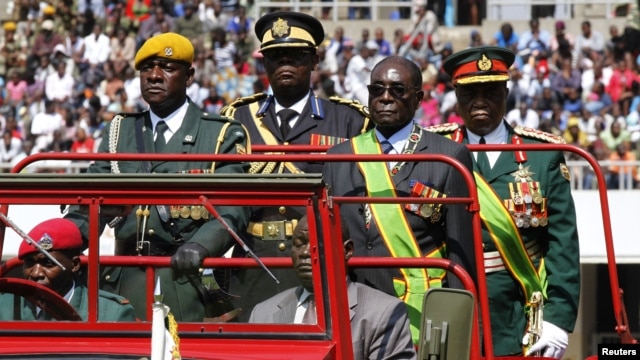 Zimbabwe's President Robert Mugabe (2nd R) arrives at the 32nd anniversary celebrations of the Zimbabwe Defense Forces Day at the National Sports stadium, in Harare, August 14, 2012.