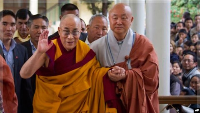 The Dalai Lama gestures as he arrives to give a religious talk at the Tsuglakhang temple in Dharamsala, India,  Oct. 23, 2011.