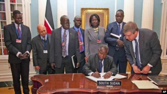 South Sudan's Minister of Finance and Economic Planning Kosti Manibe Ngai (L) signs the treaty to become IMF's newest member as US State Department Treaty Analyst Francis Holleran (R) looks on at the State Department, April 18, 2012 in Washington.


