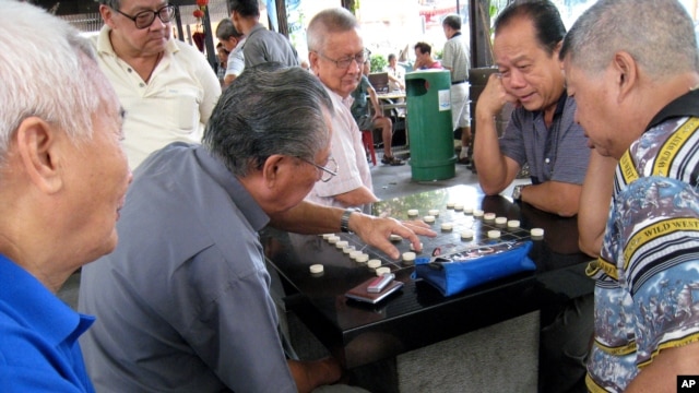 Elderly men play board games in Singapore.