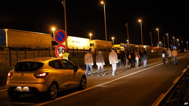 Một chiếc xe an ninh xã hội của Eurotunnel theo sau một nhóm người di cư ở Calais, miền bắc nước Pháp, hôm thứ Tư 29/7/2015.