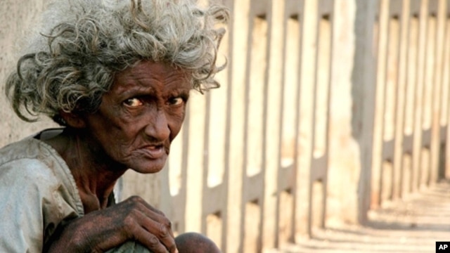 A homeless Indian woman begs on a bridge in Mumbai (file photo)