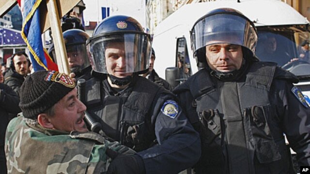 Croatian police push back an anti-EU protester attempting to remove an EU flag from the central square in Zagreb Saturday, January 21, 2012.