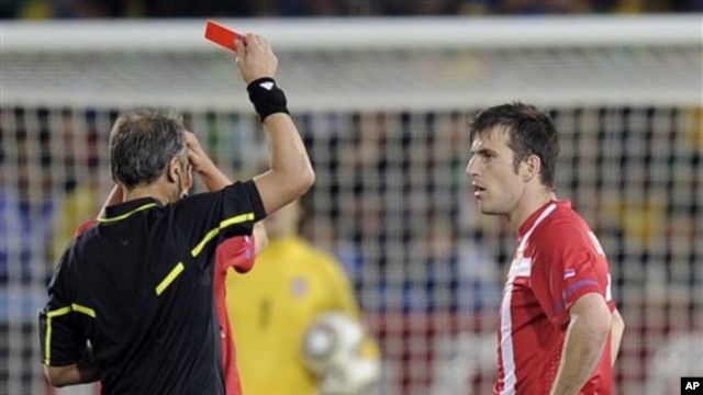 Argentine referee Hector Baldassi, left, gives a red card to Serbia's Aleksandar Lukovic during the World Cup group D soccer match between Serbia and Ghana at the Loftus Versfeld Stadium in Pretoria, South Africa, Sunday, June 13, 2010.