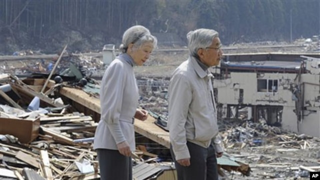 Japanese Emperor Akihito and Empress Michiko look at the tsunami-hit devastated area from the playground of Isatomae Elementary School in Minamisanriku, Miyagi Prefecture, northern Japan, April 27, 2011