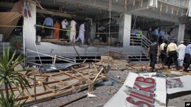 Pakistani security officials examine the site of a suicide bombing in Islamabad, Pakistan. A suicide bomber blew himself up at a busy market in the Pakistani capital, killing at least one person in the first bombing in Islamabad in over a year and a half,