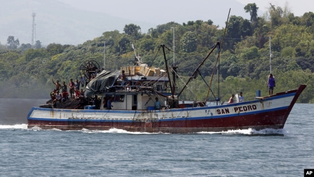 Filipino fishermen wave from a fishing boat bound to fish near Scarborough Shoal in Masinloc, Zambales May 10, 2012. 
