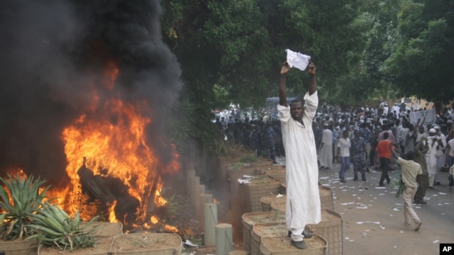 A Sudanese protester stands on a barricade during a demonstration in Khartoum, September 14, 2012, as part of widespread anger across the Muslim world about a film ridiculing Islam's Prophet Muhammad. 