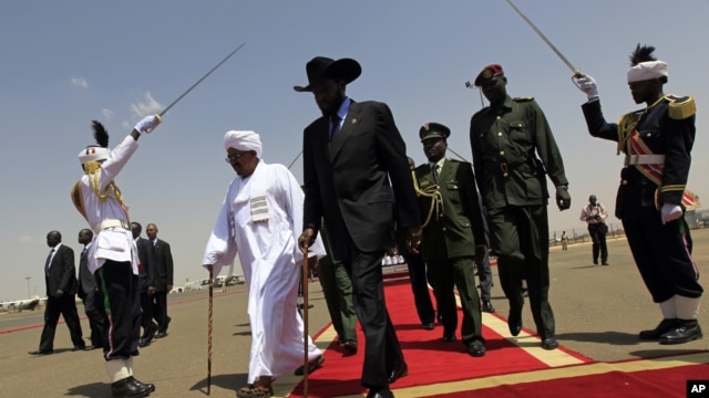 South Sudanese President Salva Kiir, center, walks with Sudanese counterpart Omar al-Bashir, Khartoum, Oct. 2011 (file photo).