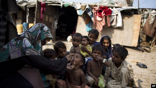 A Pakistani health worker administers polio vaccine to children in a slum of Rawalpindi, Pakistan.