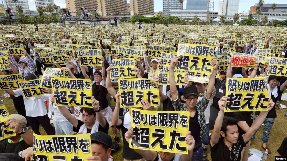 Những người biểu tình giơ biểu ngữ với dòng chữ "Sự tức giận đã vượt quá giới hạn" trong cuộc tuần hành phản đối sự hiện diện của quân đội Mỹ trên đảo Okinawa, ngày 19 tháng 6 năm 2016.