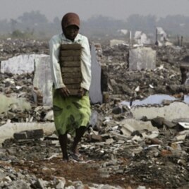 A resident collects bricks near houses flooded by mud flows from a volcano in Porong, East Java Province May 29, 2009.