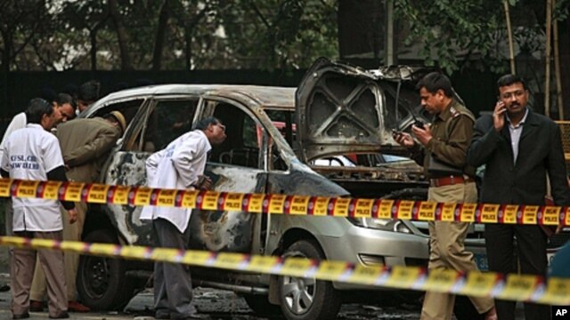 Indian police forensics experts investigate the scene after an explosion tore through a car belonging to the Israel Embassy in New Delhi, India, February 13, 2012.