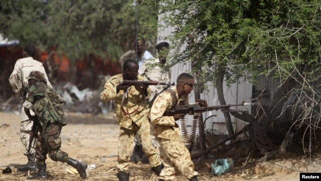 Somali government soldiers open fire during an ambush by al-Shabab rebels on the outskirts of Elasha town, Somalia, May 29, 2012.