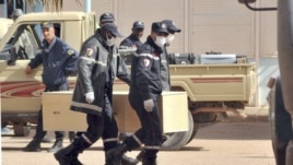 Des pompiers algériens transportant de cercueils a In Amenas, Algérie, 21 janvier, 2013. 