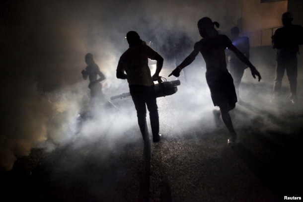 FILE - A worker of the Ministry of Public Health and Population fumigates in the street against mosquito breeding to prevent diseases such as malaria, dengue and Zika in Port-au-Prince, Haiti, Feb. 15, 2016.