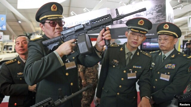 Chinese officers check rifles of ARES Defense Systems, Inc from the U.S. at the Special Operations Forces Exhibition and Conference at King Abdullah I Airbase in Amman, Jordan, May 8, 2012. 
