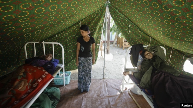 Injured people are treated outside a damaged hospital in Thabeik Kyin township, Burma, November 12, 2012.  