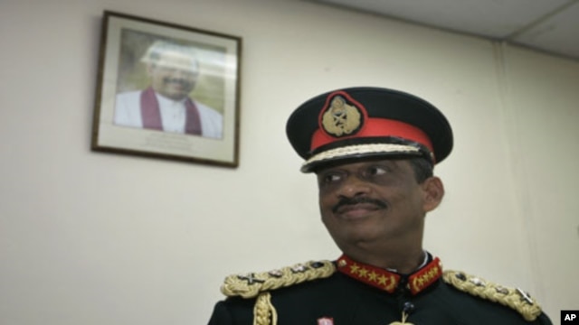 A portrait of Sri Lankan president Mahinda Rajapaksa is seen on the wall as Sri Lankan military chief General Sarath Fonseka looks on at the military headquarters after his retirement in Colombo, Sri Lanka, Monday, 16 Nov 2009
