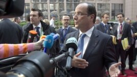 French President Francois Hollande gestures as he speaks to reporters upon his arrival for an EU summit, at the European Council building in Brussels, May 23, 2012.