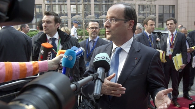 French President Francois Hollande gestures as he speaks to reporters upon his arrival for an EU summit, at the European Council building in Brussels, May 23, 2012.