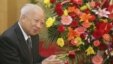 Then Cambodian King Norodom Sihanouk stands beside flowers given by the Chinese government during a meeting with Chinese State Councilor Dai Bingguo (not seen) in Beijing, October 30, 2006.