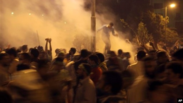 Supporters of Egypt's ousted President Mohammed Morsi run for cover from tear gas fired by riot police during clashes at Nasr City, where protesters have installed their camp and hold their daily rally, in Cairo, Egypt, July 26, 2013.
