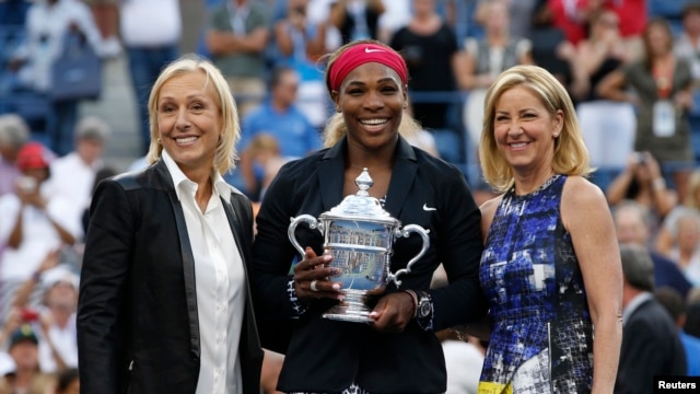 Serena Williams holds her trophy while flanked by tennis greats Martina Navratilova (L) and Chris Evert following the women's singles finals match at the 2014 U.S. Open tennis tournament in New York, September 7, 2014.