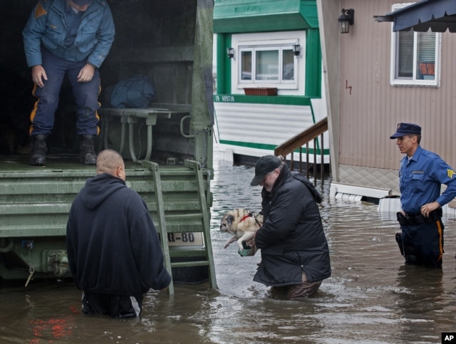 A man walks with his dog to a National Guard vehicle after leaving his flooded home in Moonachie, New Jersey, after Hurricane Sandy on Oct. 30, 2012.