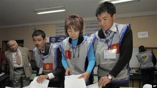 Members of local electoral committee sort through a ballot box, at a polling station in Bishkek, Kyrgyzstan, 10 Oct. 2010.