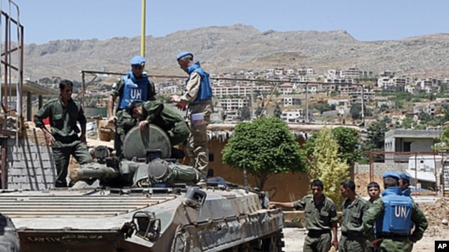 United Nations (U.N.) observers examine a Syrian army tank during a field visit to the al-Zabadani area, near Damascus, May 6, 2012. Al-Zabadani is one of the locations where protests against the regime of Syrian President Bashar al-Assad were being held.