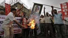 Activists of Socialist Unity Center of India (SUCI) burn an effigy with a portrait of Indian Prime Minister Manmohan Singh during a protest in Kolkata, India, September 15, 2012.