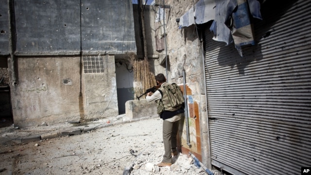 A Free Syrian Army fighter fires his weapon toward Syrian Army positions in Karmal Jabl district in Aleppo, Syria, Oct. 21, 2012. 