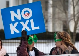 Hai phụ nữ đeo kính râm hình cái cây ăn mừng quyết định bác bỏ dự án Keystone XL của Tổng thống Obama.