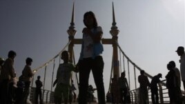 Cambodians walk on a bridge (now removed) on which hundreds of people stampeded during a water festival on Nov. 22, 2010.