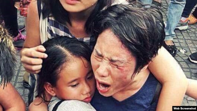 Bà Hoàng Mỹ Uyên ôm con gái trong vụ xô xát giữa lực lượng an ninh Việt Nam với người biểu tình hôm 8/5 ở Sài Gòn. 