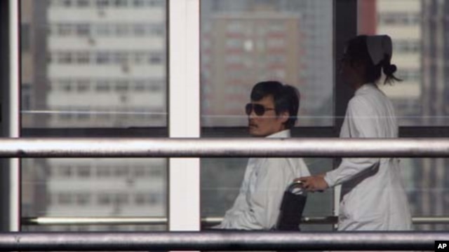 TOPSHOTS
Chinese activist activist Chen Guangcheng (L) is seen in a wheelchair pushed by a nurse at the Chaoyang hospital in Beijing on May 2, 2012.  A US official said there would be no repeat of the incident involving the activist Chen Guangcheng, but 