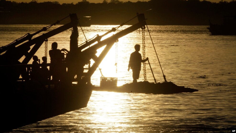 A passenger stands on the foredeck of a ferry as it crosses the Mekong river from Arey Ksat to the main city in Phnom Penh, Cambodia, July 1, 2016.