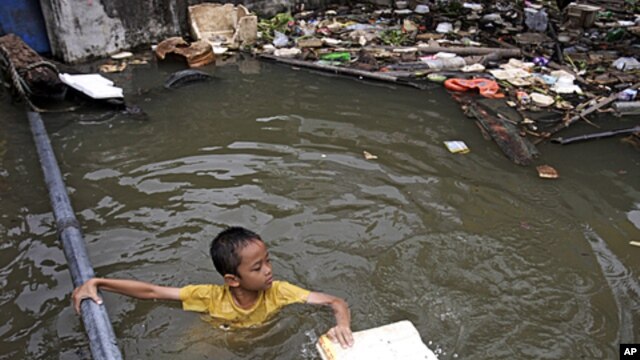 A Thai boy plays at a flooded area in Bangkok, Thailand. Hundreds of people have died across Southeast Asia, China, Japan and South Asia in the last four months from prolonged monsoon flooding, typhoons and storms, October 3, 2011.