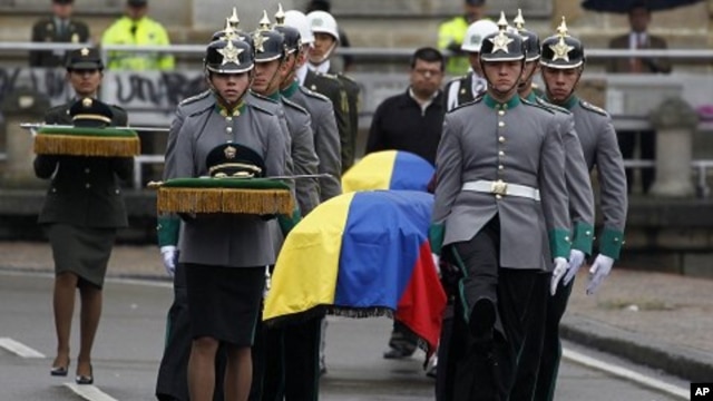 Colombian honor guards carry the coffins of four members of the security forces during their funeral at Bogota's cathedral, November 29, 2011.