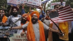Miembros del Akali Dal, un partido político sij, muestran espadas y letreros de protesta en Nueva Delhi